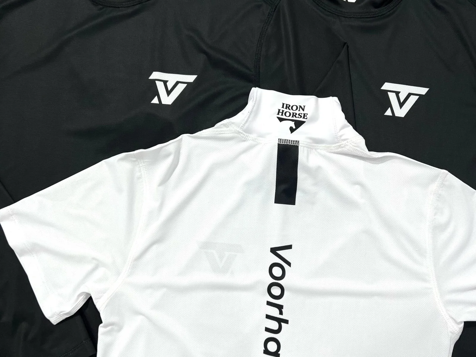 Black and white performance shirts with custom printed branding, produced at the Iron Horse factory in Vietnam